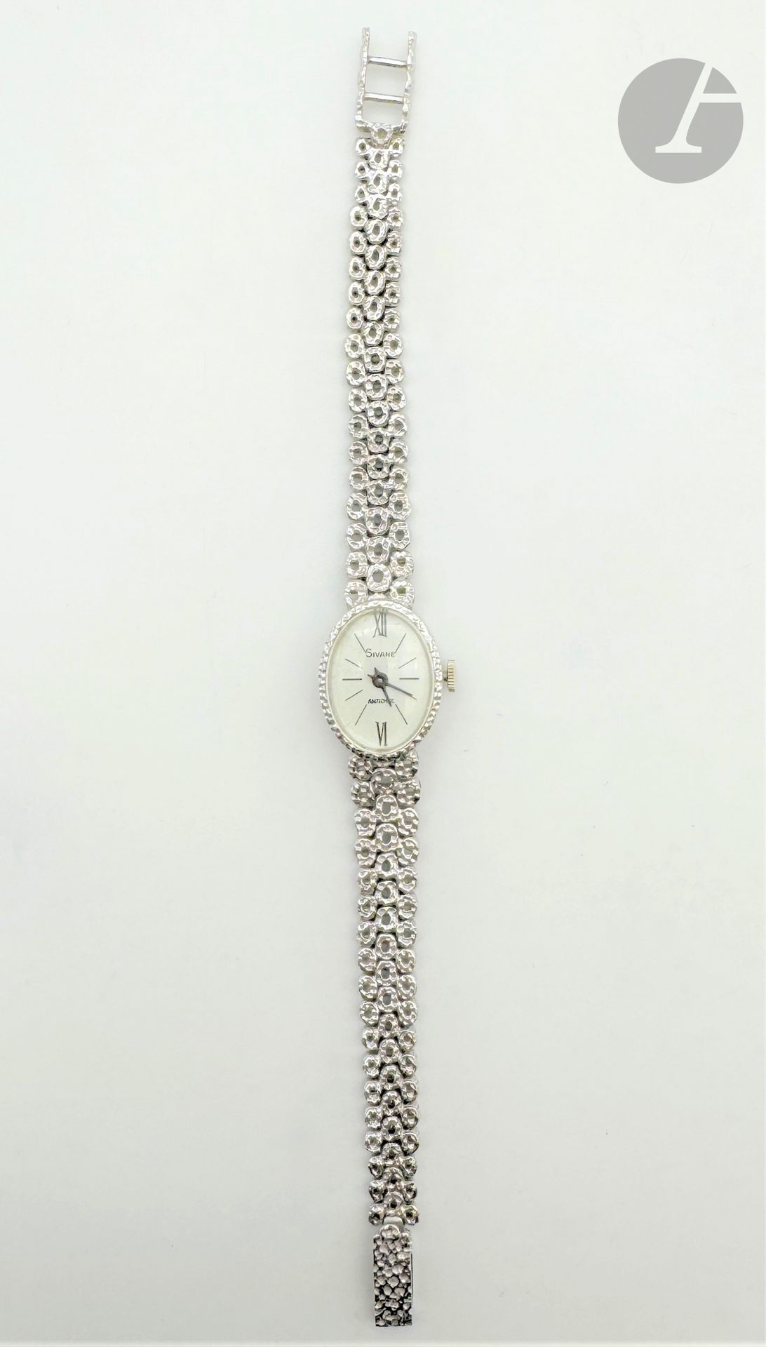 SIVANE
Montre de dame en or gris 18K (750), cadran ovale, index bâtons et chiffres arabes, le bracelet articulé de maillons arrondis en or 18K martelé. Signée. Longueur : 15,5 cm environ. Poids brut : 25,5 g (fonctionnement non garanti)