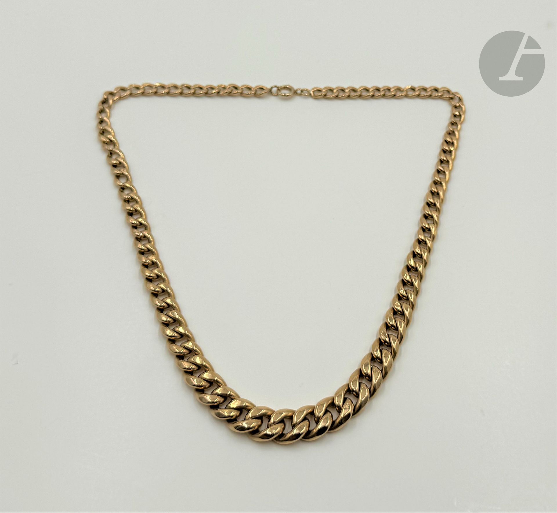Collier gourmette en or 18K (750) articulé de maillons ovales imbriqués en chute. Longueur : 49,5 cm environ. Poids brut : 21 g (enfoncements, or creux)