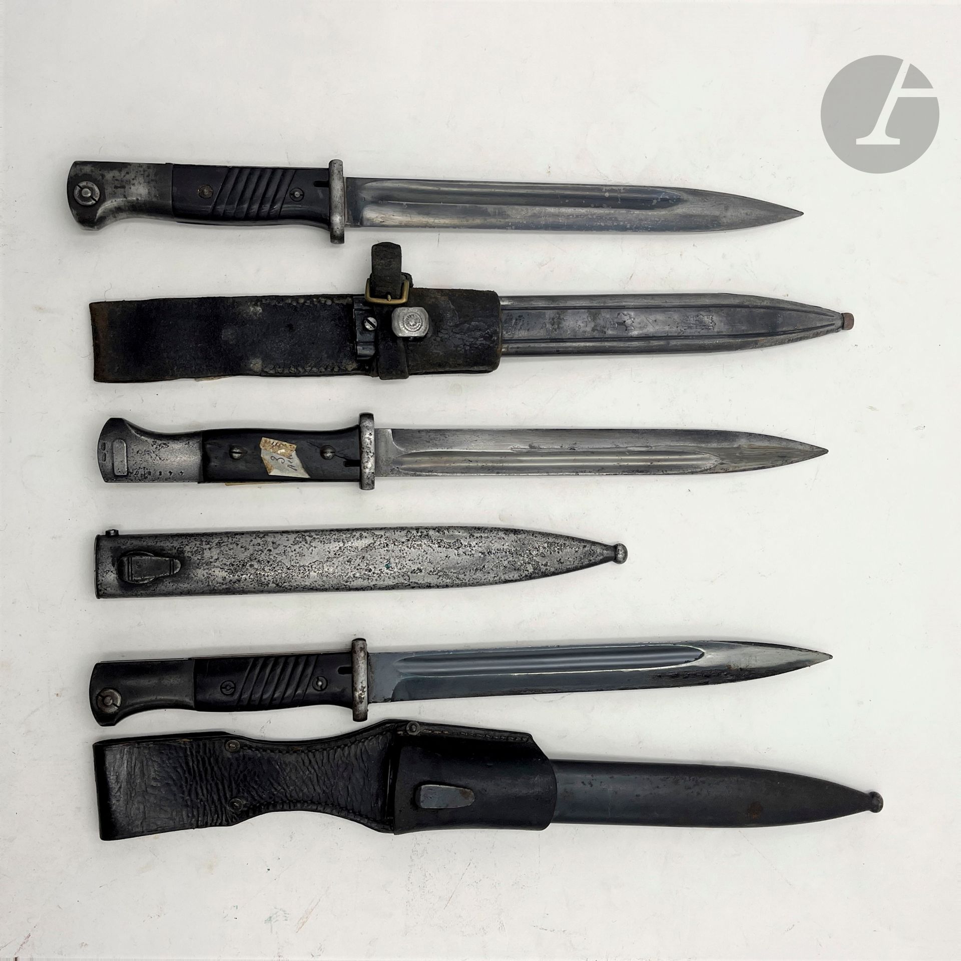 ALLEMAGNE 
Trois baïonnettes 1884-98 : 
- une à plaquettes bois. Lame bleuie sans marquages. A.B.E. 
- une à plaquettes synthétiques. Lame datée 40, marquée «agv» Fourreau en tôle rainurée. Gousset en cuir.
- une à plaquettes synthétiques. Lame marquée «WKC» Fourreau en tôle bronzée. Gousset en cuir.