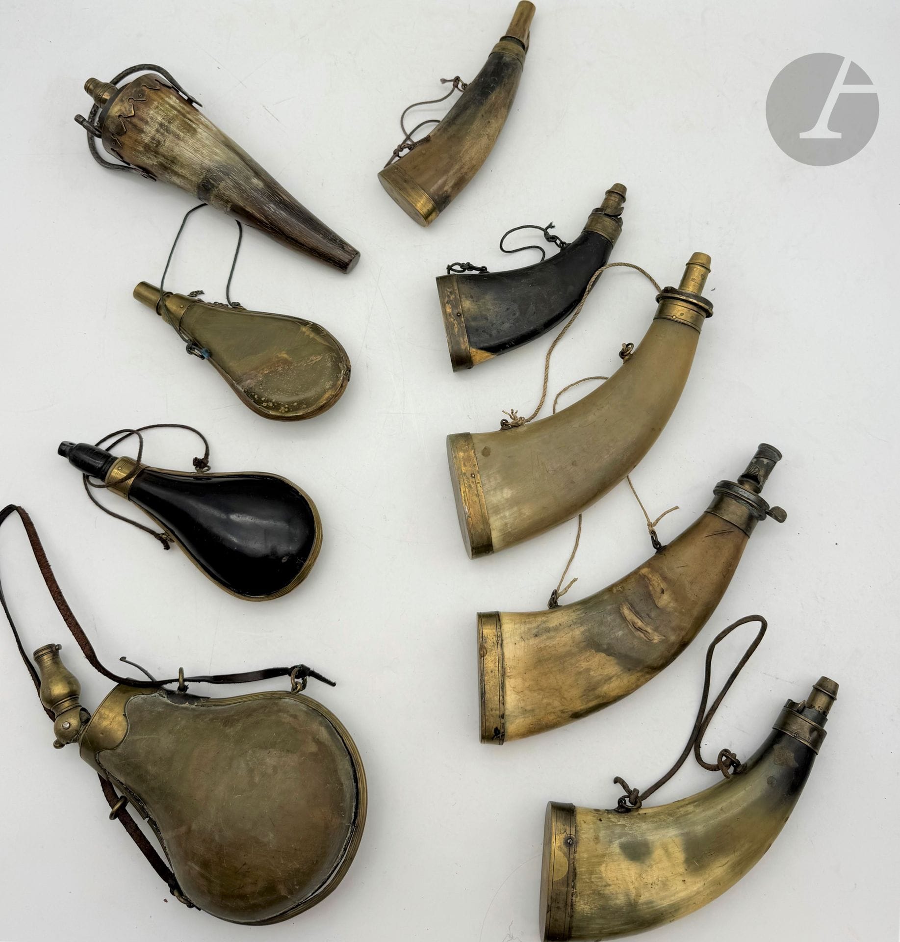 °Lot de neuf poires à poudre en corne, à garniture en laiton, certaines à bec doseurs.
E.M. et A.B.E.