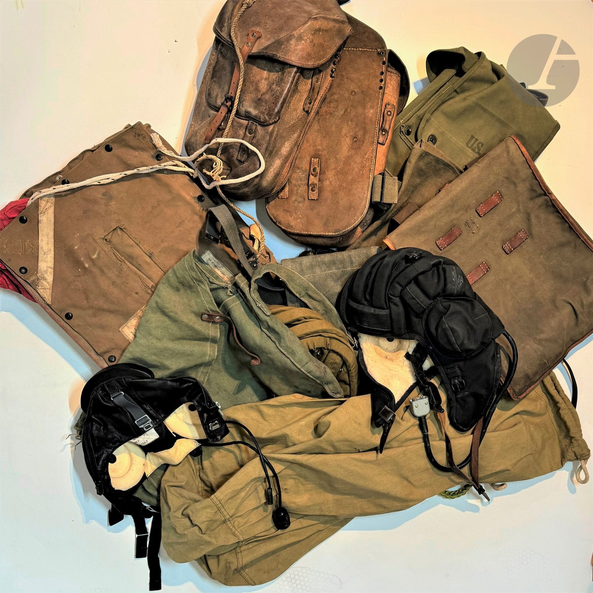 Fort lot de militaria: 
Casque de saut, sacs divers, gilet, havresac allemand 1936 SACHS & DEISSELBERG HAMBURG, matriculé 31,5, toile camouflée Algérie, sac U.S., gourde française 1re G.M, fourragères françaises.