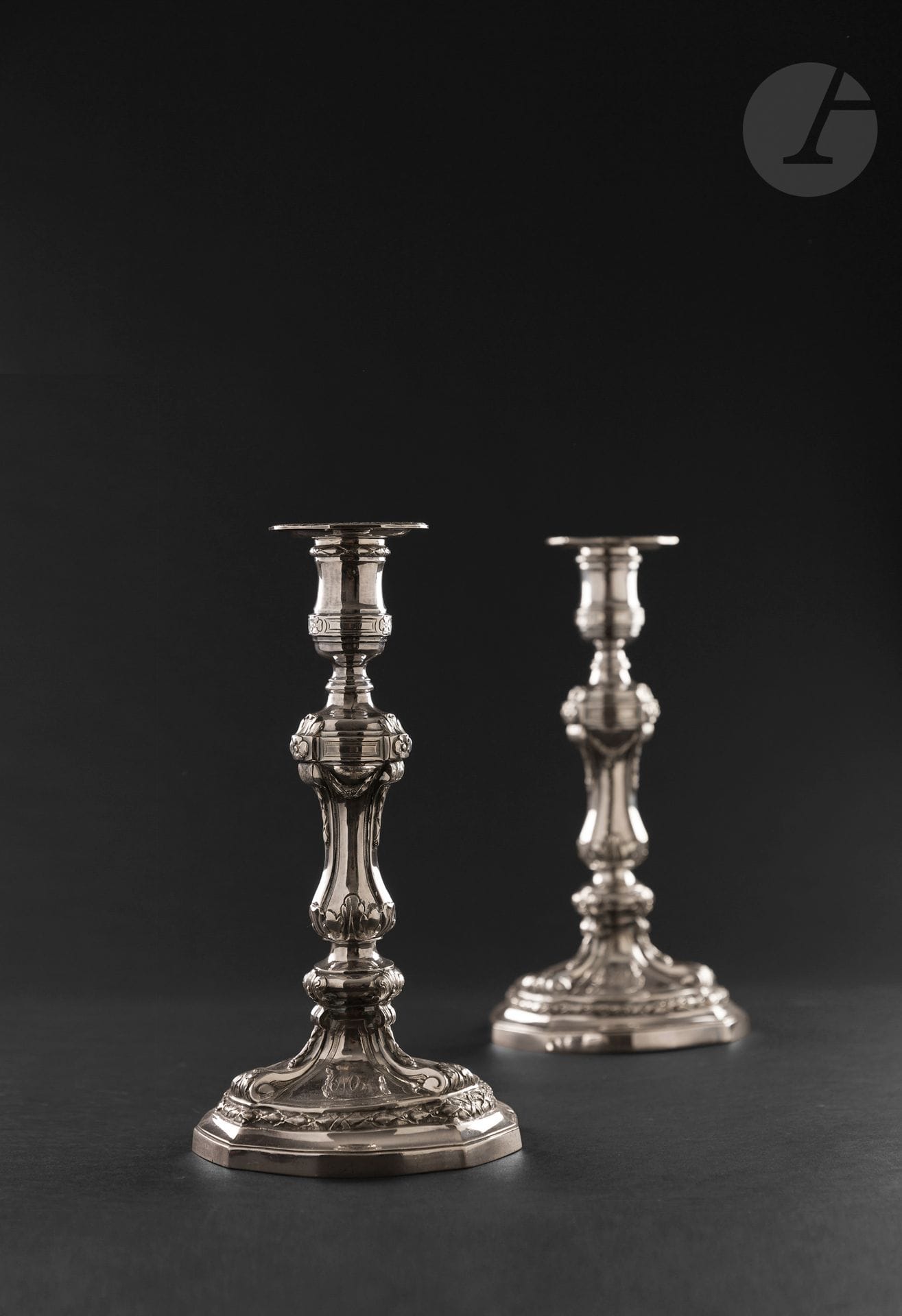 TOULOUSE 1788
Pair of silver candlesticks and bobèches. The hexagonal base with alternating sized sides is followed by a row of laurels and crosses on the top of the spigot and the rim of the candleholders. The six-sided shaft is embellished with acanthus leaves and falling garlands extending the bowl, which is underlined by three geometrical motifs, one of which is engraved with a later interlaced numeral.
Master goldsmith : Louis II DULAURIER, received in 1765
Weight : 1353 g - height without bobèches : 28 cm - base diameter : 15 cm