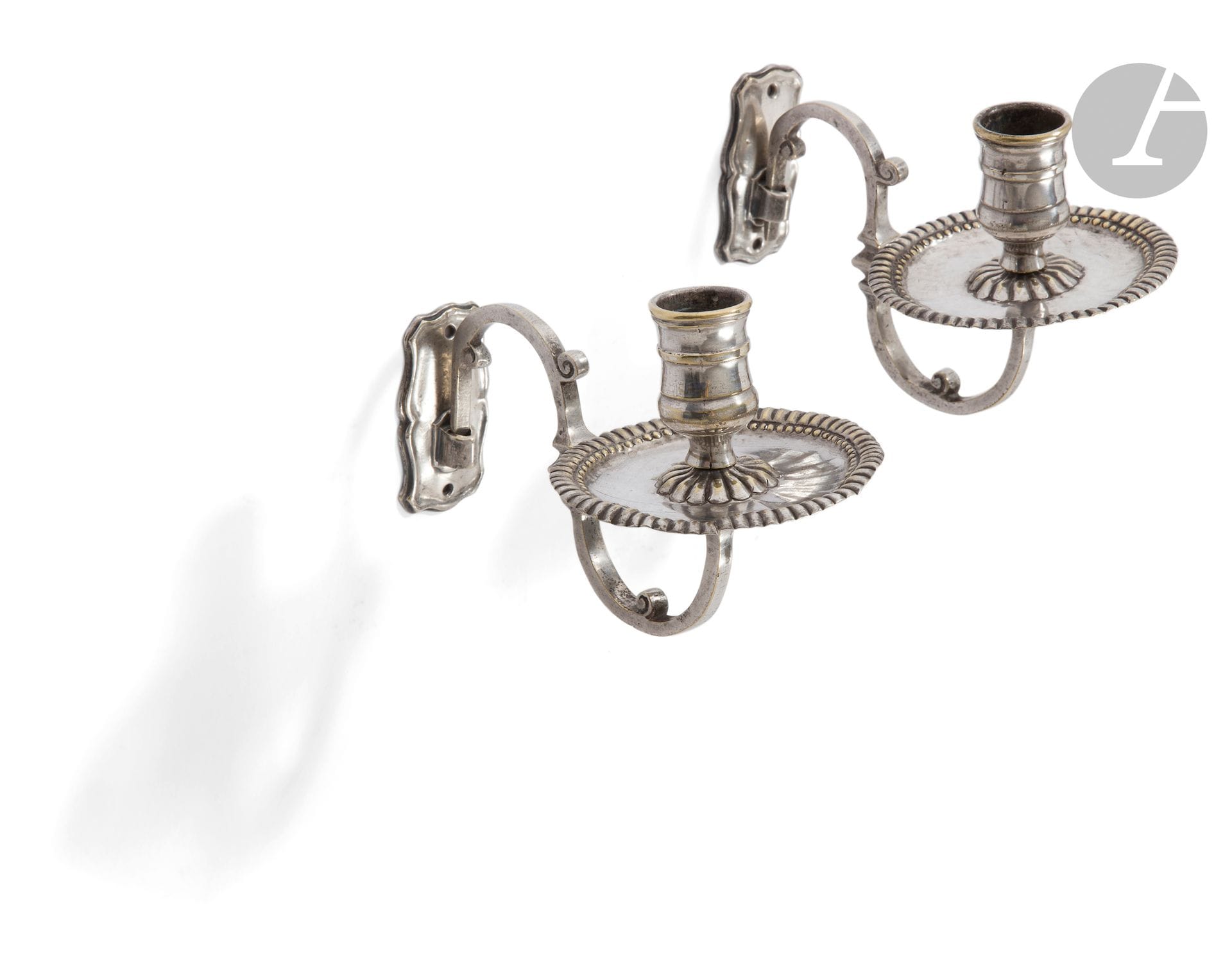 FRANCE 18th CENTURY
Pair of wall-mounted candlesticks in silver-plated metal, molded with gadroons, complete with their bracket in the form of a console with three scrolls.
Plate height: 6.5 cm, Depth: 14.5 cm 
Condition