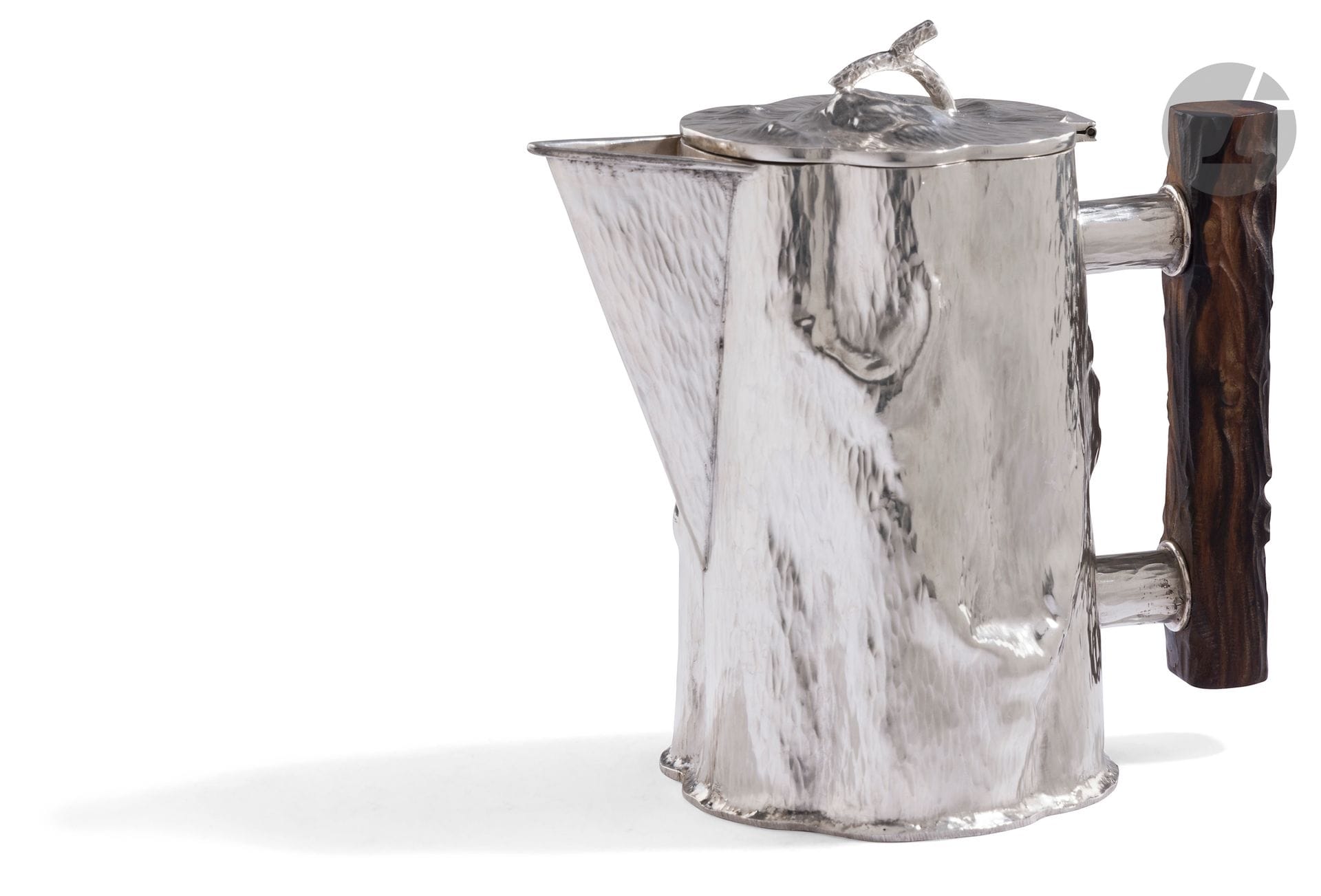 ITALY CIRCA 1970
800°/°° silver teapot and spout with filter, truncated cone shape imitating a hammered tree trunk. The handle, in macassar ebony, is left natural and attached to the body by two hoods. 
Retailer: SPRITZER &amp; FUHRMANN, made in ITALY
Gross weight: 670 g - Height: 19 cm