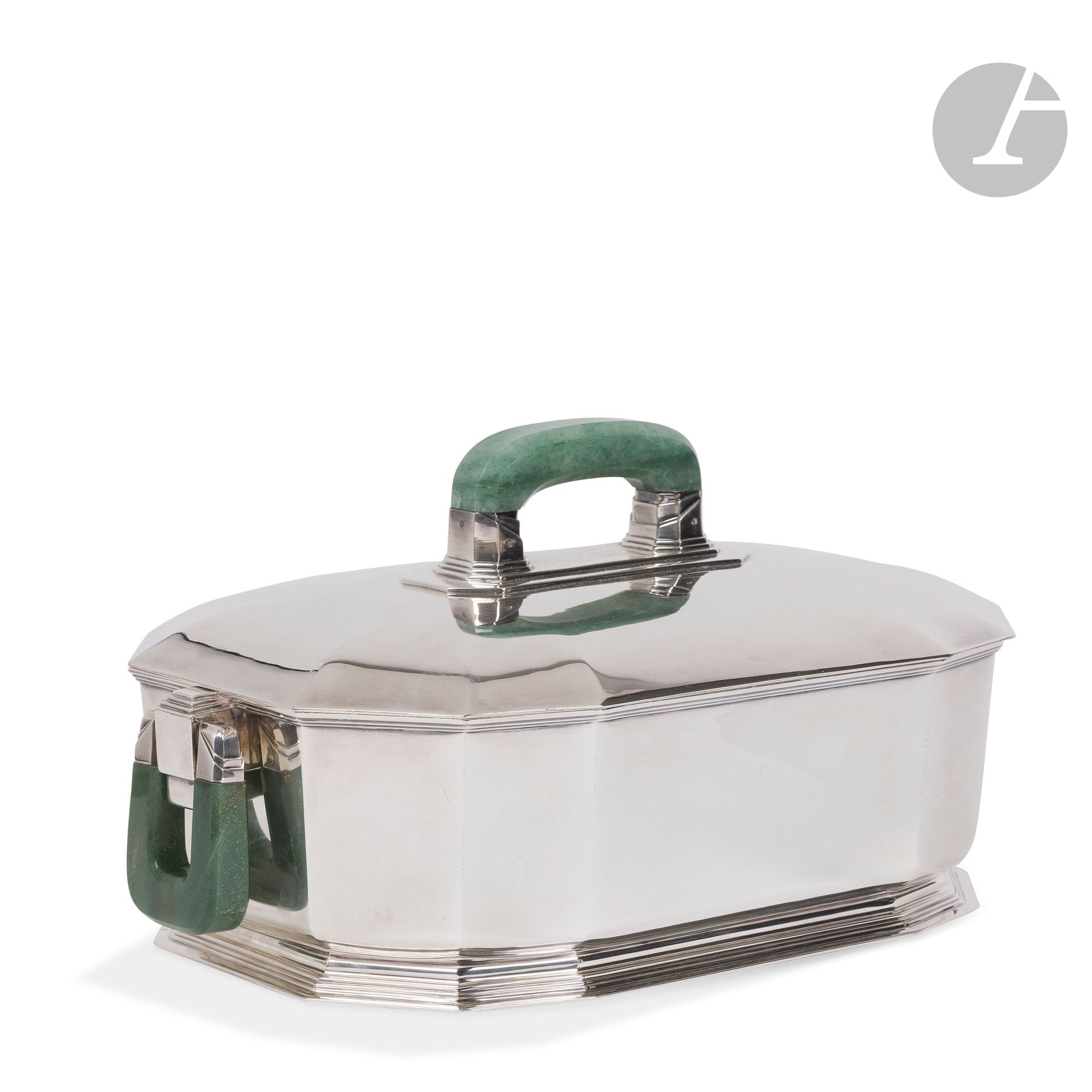 JEAN-ÉMILE PUIFORCAT (1897-1945) (JEAN-ÉLISÉE PUIFORCAT, DIT) CRÉATEUR DU MODÈLE – MAISON PUIFORCAT PARIS ORFÈVRE
Douze pans, le modèle créé vers [1923]
Rare soupière en argent formant centre de table.
La base facettée reposant sur un talon à gradinset flanquée de deux anses articulées en aventurine sculptée; les attaches en argent aux motifs plissés.
Le couvercle bombé et aux arêtes s’estompant; la prise fixe en aventurine sculptée; les attaches en argent aux motifs plissés.
Édition ancienne.
La base marquée Jean E. PUIFORCAT - Paris au revers, la base et le couvercle portent les poinçons de Maître Orfèvre et de titre.
Hauteur: 22cm – Longueur: 40cm – Largeur: 26cm
Poids brut:4.916g

Provenance:
Collection particulière, Neuilly-sur-Seine.

Bibliographie:
- Beaux-Arts – N°10 du 1er juin 1923. Modèle identique aux légères variantes d’attaches des prises reproduit pageV.
- Art et Décoration – Juin 1923. Modèle identique aux légères variantes d’attaches des prises reproduit page 184.
- Gaston Quénioux – Les Arts Décoratifs Modernes – Éditions Larousse, Paris, 1925. Modèle identique aux légères variantes d’attaches des prises reproduit page174.
- Fernand David (préface) – L’Art décoratif français 1918-1925 – Éditions Albert Lévy, Paris, vers 1929. Modèle identique aux légères variantes d’attaches des prises reproduit page 174.
- Collectif – Jean Puiforcat; orfèvre sculpteur - Éditions Flammarion, Paris, 1951. Modèle identique aux légères variantes d’attaches des prises reproduit dans cette publication sans pagination pour les planches.
- Françoise de Bonneville – Jean Puiforcat – Éditions du Regard, Paris, 1986. Modèle identique aux légères variantes d’attaches des prises reproduit page 86.