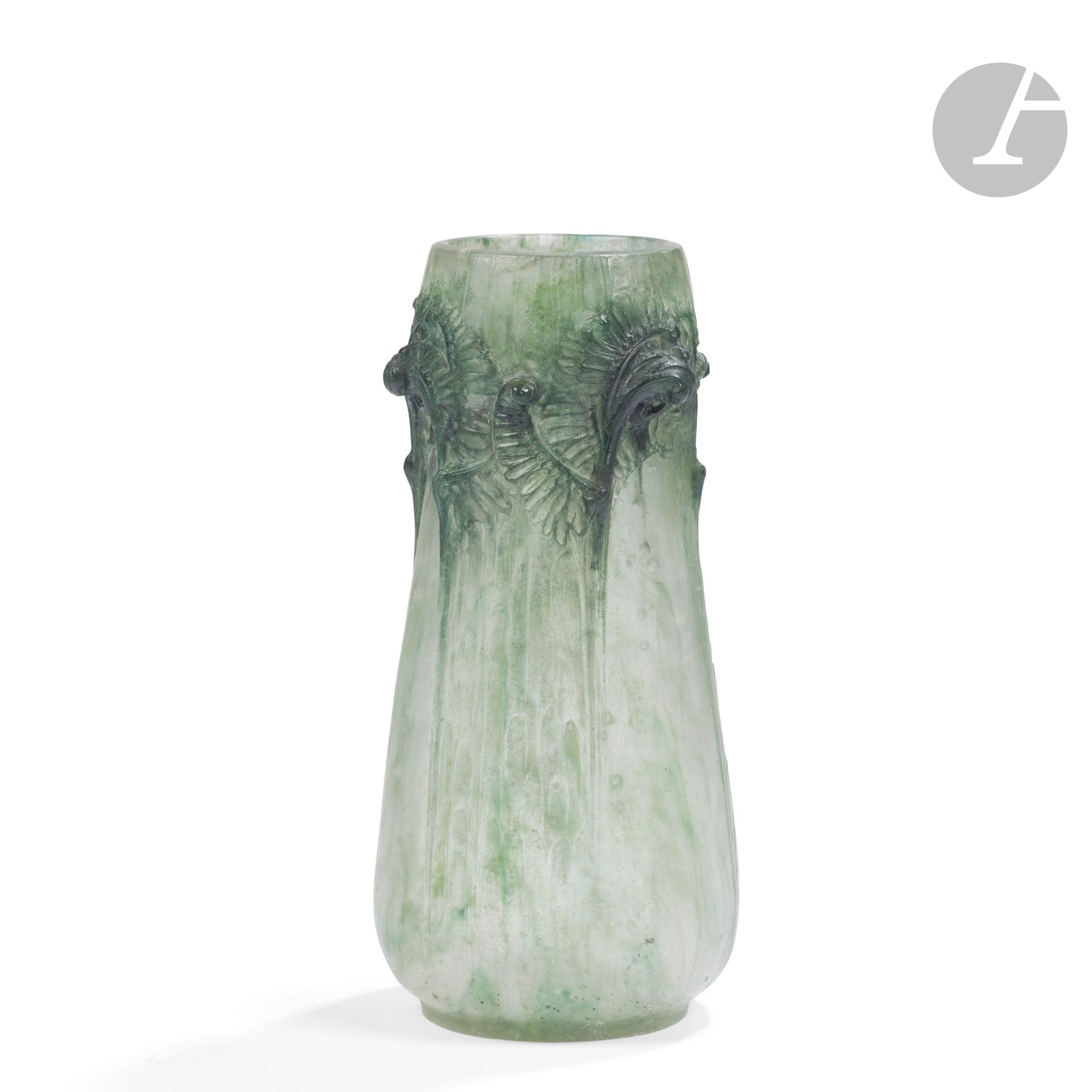 FRANÇOIS-ÉMILE DÉCORCHEMONT (1880-1971)
Vase fougères en hauteur, le modèle créé en [1913] et diffusé jusqu’en [1914], réputé avoir été édité à7 exemplaires
Vase piriforme évoquant une coloquinte; le décor titre en haut-relief. 
Épreuve en pâte de verre polychrome; vert d’eau nuancé de vert foncé, la panse bullée évoquant la rosée du matin.
Deux importantes fêlures (stoppées) démarrant sous la base possiblement lors de l’élaboration de la pièce, infimes égrenures en pourtour du col, un petit éclat au talon.
Marqué du cachet de l’artiste vers la base.
Hauteur: 23cm

Collections publiques:
Kitazawa Museum of Art, Tokyo – Un modèle identique (variante de couleurs) est conservé dans cette institution.

Bibliographie: 
Véronique Ayroles – François Décorchemont – Maître de la pâte de verre – Éditions Norma, Paris, 2006. Modèle référencé sous le n°46 à la page 236, des variantes de couleurs reproduites page 89 et 237.