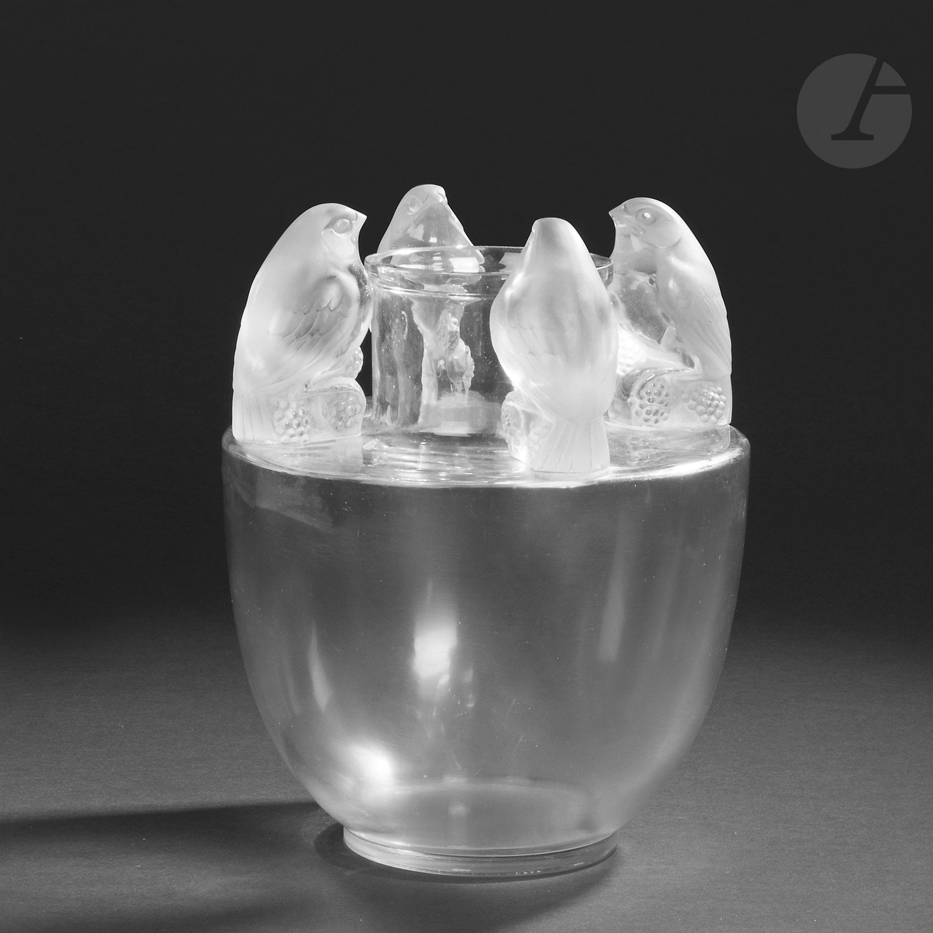 RENÉ LALIQUE (1860-1945)
Bellecourdit aussi Quatre moineaux, le modèle conçu le [18 janvier 1927], non repris après 1947
Rare vase balustre; l’épaulement à arête vive et recevant les décors de moineaux en ronde-bosse, le col de type cheminée.
La base en verre soufflé-moulé; les prises, figurant des moineaux, en verre moulé-pressé et collées à chaud (réf. Marcilhac 993). 
Signé R. LALIQUE France n°993 sous la base. Hauteur: 30,5cm