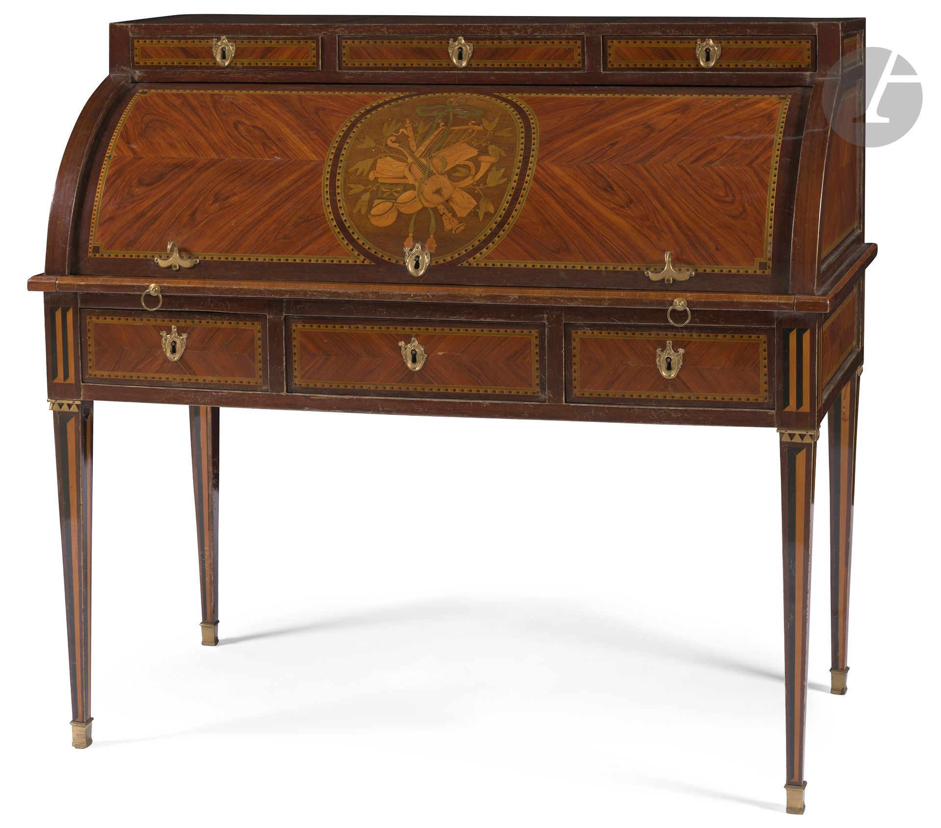 Secrétaire à cylindre en marqueterie de trophée musique, bois de rose et amarante (toutes faces), ouvrant à six tiroirs et un cylindre découvrant une tablette coulissante, quatre tiroirs et un compartiment, reposant sur des pieds en gaine; (petits accidents et restaurations).
Époque Louis XVI.
H.106cm, L.113cm, P.58cm