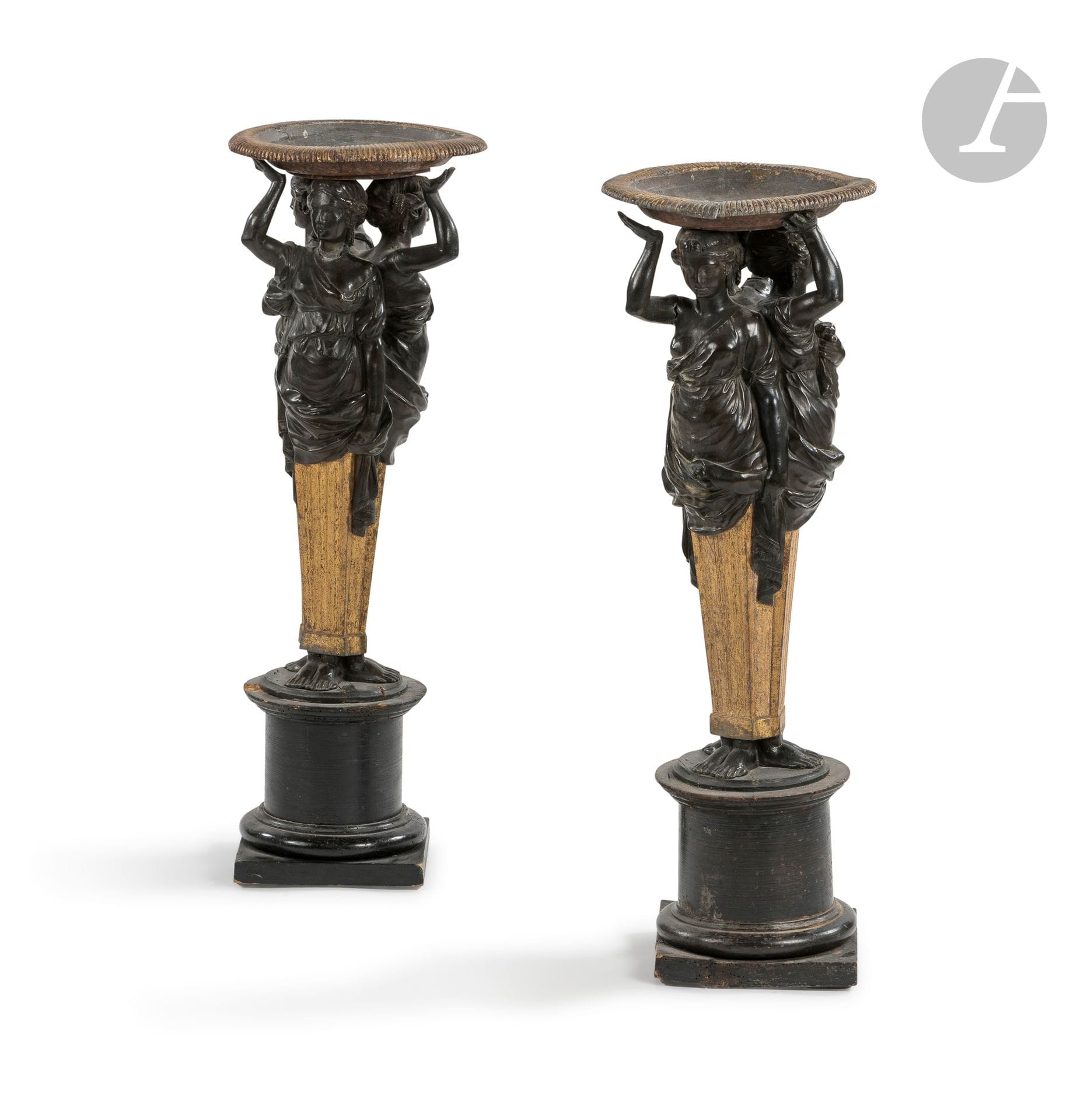 Paire de grandes coupes aux caryatides en bronze patiné, plomb doré et bois noirci, à trois figures adossées, reposant sur une base circulaire. ; (accidents et manques).
Vers 1840.
H : 78 cm