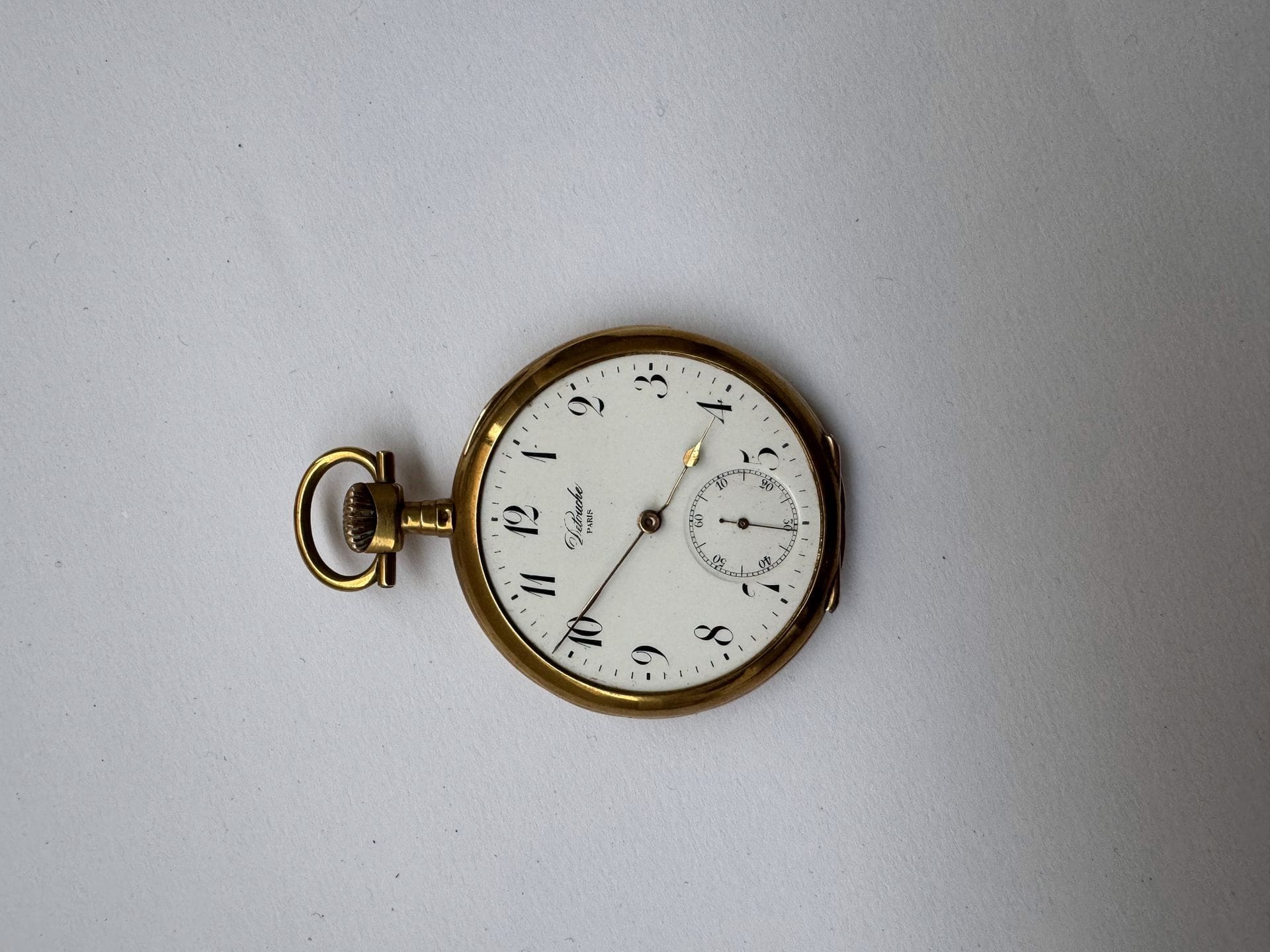Small pocket watch in 750/°°° 18K gold, white enameled dial, Arabic numerals. 
Double-shell gold caseback.
Eagle head hallmark.
Gross weight: 70 g (without glass).
Cost of gold coins and lots: 9.6% incl. VAT - 8% excl.