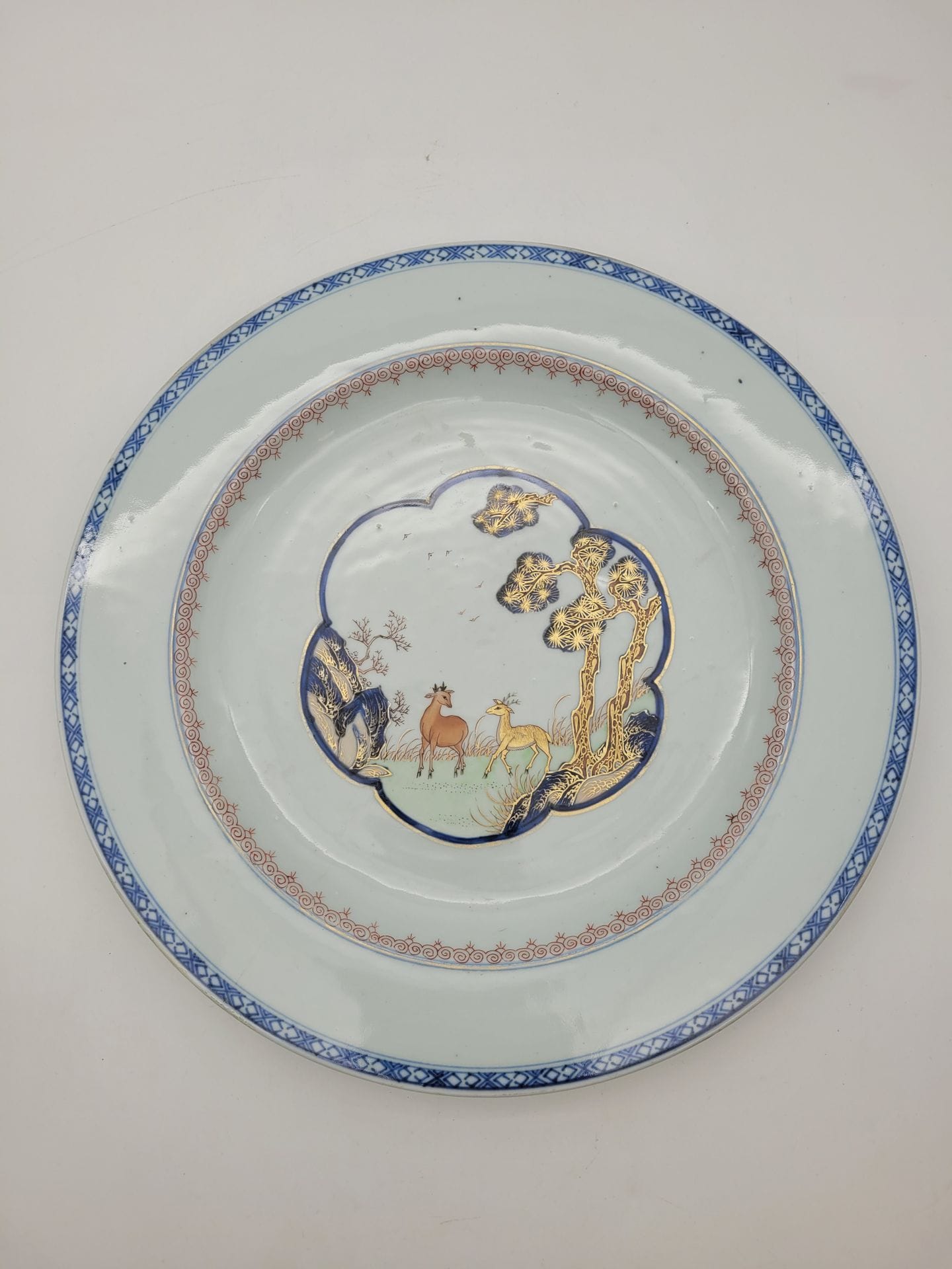 Large porcelain dish, China, Compagnie des Indes, 18th century
Centrally decorated with two deer in a pine landscape in blue underglaze and gilding.
Diameter: 35.8 cm
Fels and restorations.