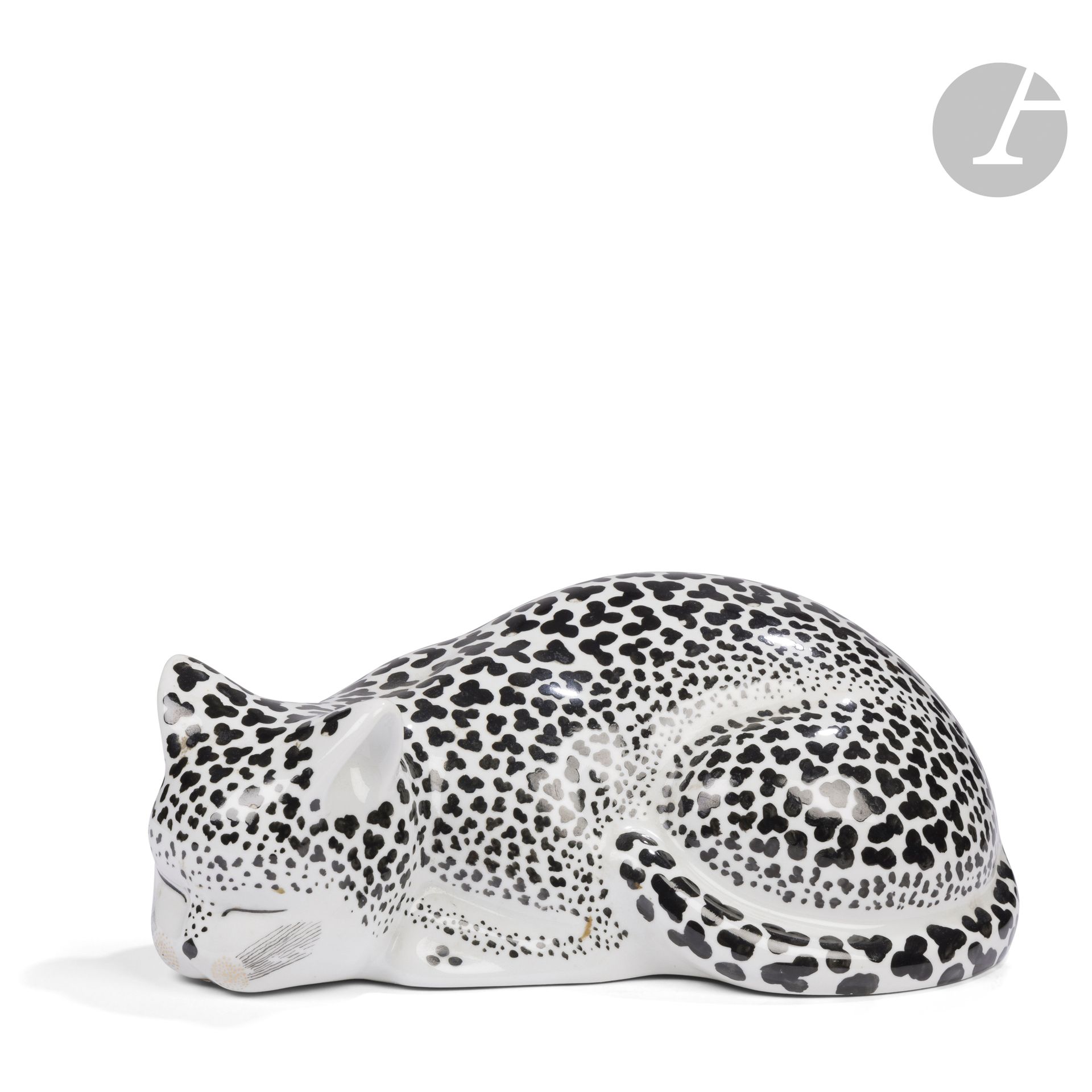PIERO FORNASETTI (1913-1988) (CRÉATEUR DU MODÈLE) &FORNASETTI MILANO ÉDITEUR
Chat tigré allongé
Sculpture décorative à poser. Épreuve en porcelaine blanche; la robe tachetée de noir. Petits sauts d’émail épars. Marquée du cachet bleu-vert FORNASETTI Milano Made in Italy au revers.  H.13cm – L.32cm – l.18cm