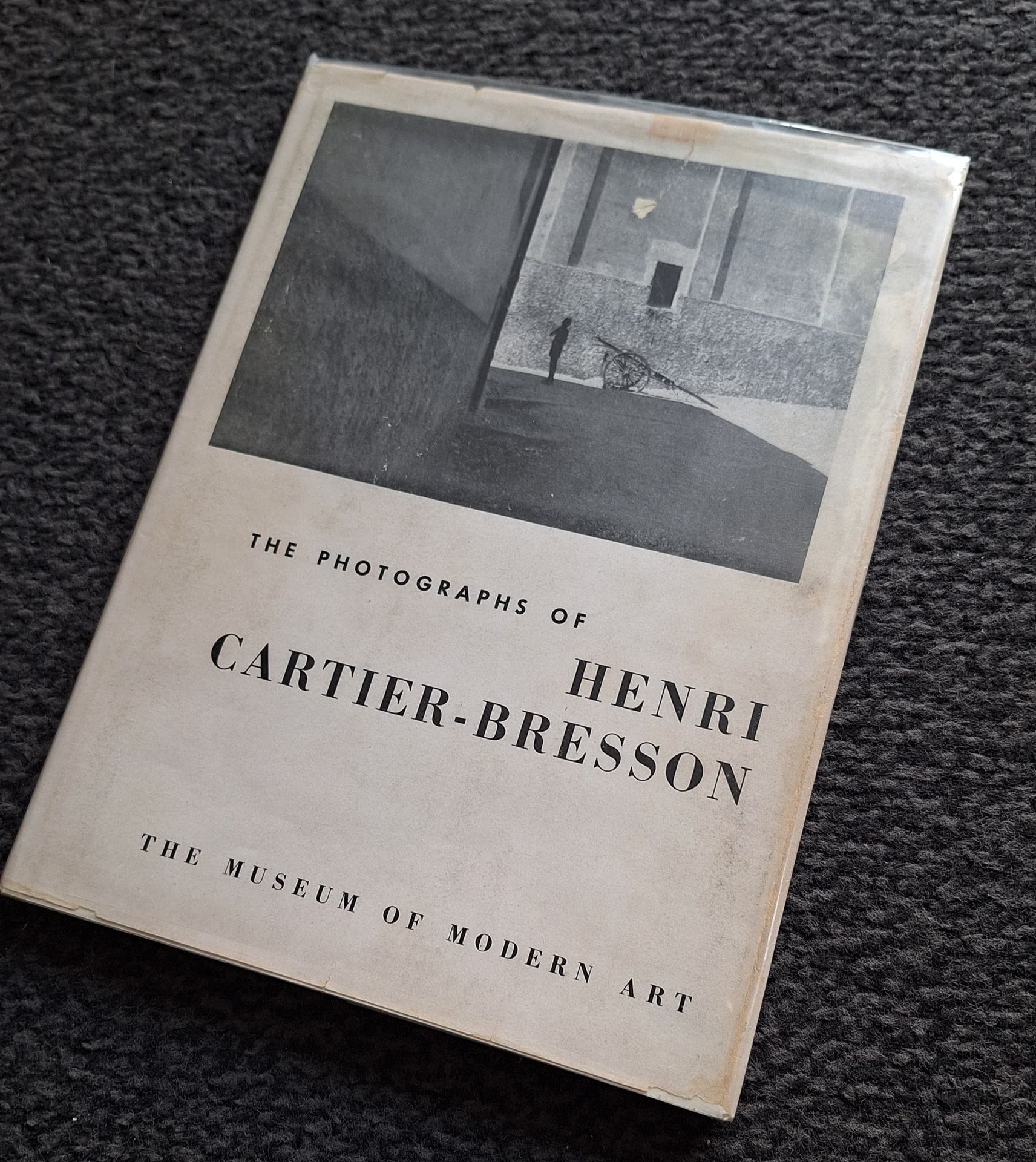 CARTIER-BRESSON, HENRI (1908-2004) 
The photographs of Henri Cartier-Bresson. 
The Museum of Modern Art, New-York, 1947. 
In-8 (25 x 19 cm). Édition originale reliée. 56 pages. 42 photographies. Textes de Lincoln Kirstein et Beaumont Newhall. Cartonnage d'éditeur avec titre en rouge sous sa rare jaquette d'origine conservée (une petite déchirure); ex-exemplaire de bibliothèque avec 3 discrets tampons dans l'ouvrage n'en affectant pas la qualité.