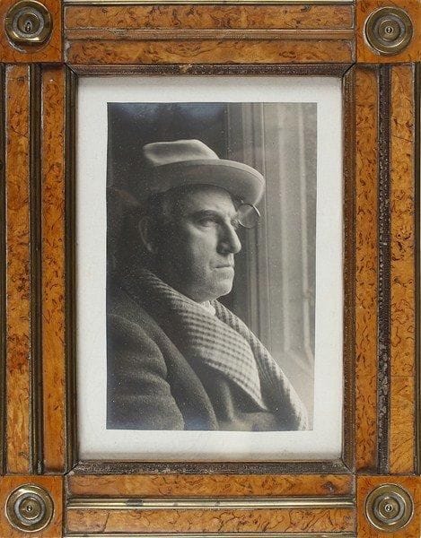 [Lucien GUITRY (1860-1925)]. Photographie; tirage argentique 15,5 x 10 cm, monté sur carte, dans un cadre en loupe d?orme et ornements de laiton doré, 25,5 x 19,5 cm.Lucien Guitry à la fin de sa vie, coiffé d?un chapeau auquel est accroché un monocle. Ce portrait est toujours resté sous les yeux de Sacha Guitry. Collection André Bernard (n° 304).On joint une photographie signée (carte postale, photo A. Bert; sous verre)