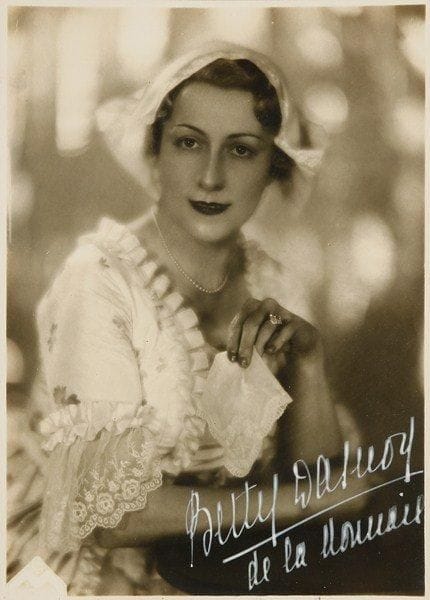 Betty DASNOY (1895-1972) soprano belge. Photographie signée; 22,5 x 16 cm (encadrée).Belle photographie (en Suzanne des Noces de Figaro ?) signée en blanc: «Betty Dasnoy de la Monnaie»