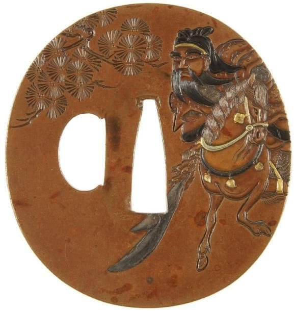 JAPON
Nagamaru gata en suaka à décor gravé en ke-bori et incrusté de cuivre jaune de Kwanyu à cheval tenant sa hallebarde près d'un pin. Signée Mitsunari.H. 7 cm