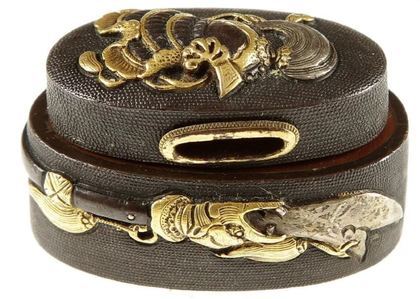 JAPON
Fushi et kashira en shibuichi à fond de nanako décoré en relief et incrusté de shibuichi et cuivre jaune d'un kabuto et lance