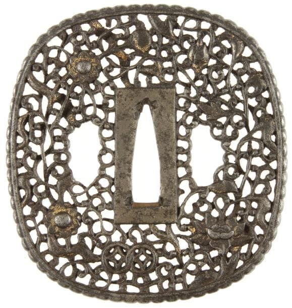JAPON
Epoque EDO (1603 - 1868) Nadegakuhokkei gata en fer à décor ciselé et ajouré  avec incrustations en nunome zogan de cuivre jaune de fleurs et rinceaux feuillagés. Style namban. H. 8,3 cm.