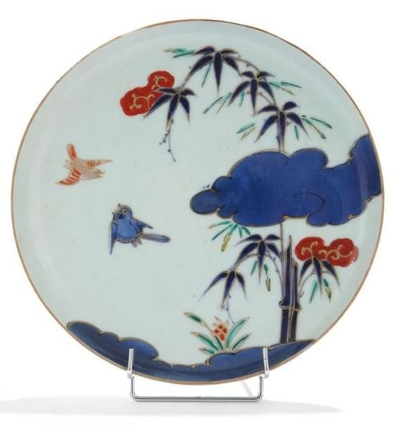 JAPON - XIXE SIÈCLE
Coupe en porcelaine décorée en bleu sous couverte, rouge de fer et émail or de deux oiseaux volant parmi les bambous. Imari. Au revers, la marque "Fu gui chang chun". Diam.: 25 cm