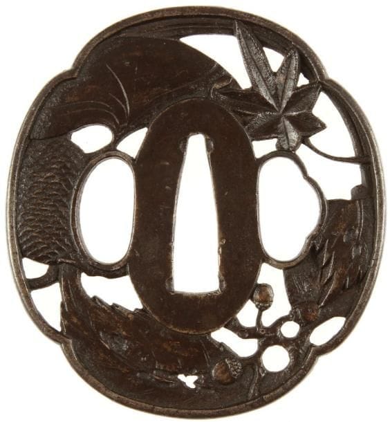 JAPON
Mokko gata en fer à décor ciselé et ajouré en marubori de feuilles de ginko, glands feuille d'érable et pomme de pin.H. 6,8 cm