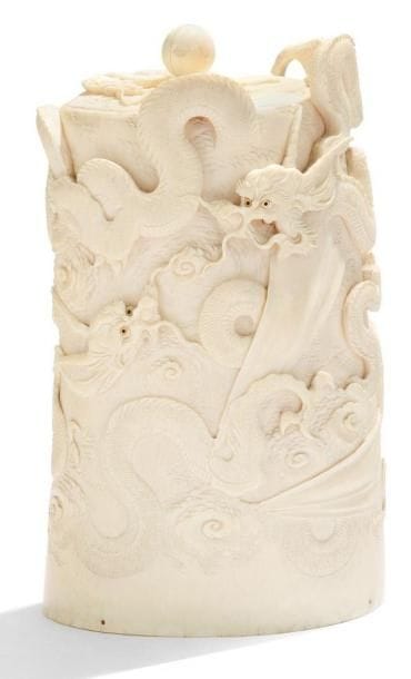 JAPON - Epoque MEIJI (1868-1912)
Pot couvert en ivoire à décor sculpté en haut relief de trois dragons parmi les nuages, le couvercle sculpté d'un dragon pourchassant la perle sacrée parmi les nuages. (Accident au couvercle, manque la cartouche). H.: 19 cm