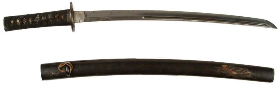 Armes JaponaisesShinshinto wakizashi, unokubi zukuri, fusée percée d'un mekugi ana avec une signature incrustée de cuivre kuni. La lame ornée d'un kanemono à décor de poème et sabre. Nagasa.Fourreau en laque noir décoré en hira maki-e de laque or et rouge de ballots de riz sur une barque.(Accidents, fusée rouillée) Long.: 44,2 cm