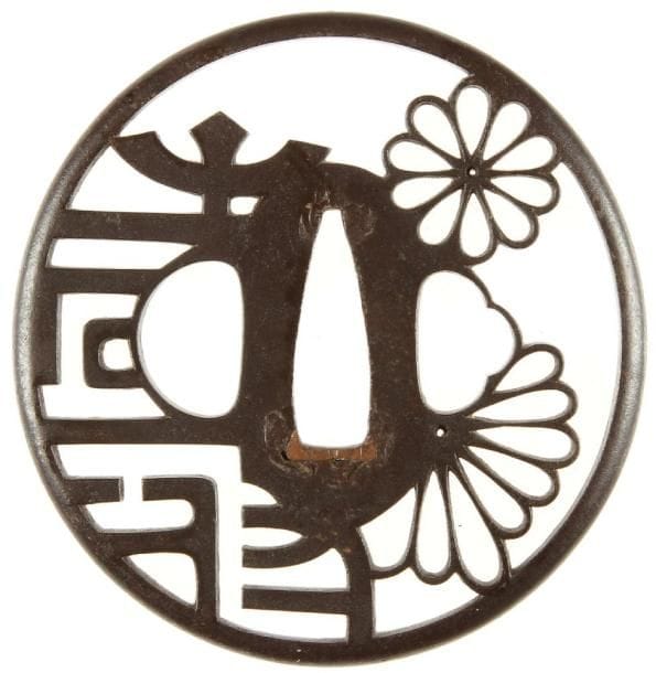 JAPON
Nagamaru gata en fer à décor ajouré en yo sukashi d'un caractère et chrysanthèmes.H. 7,1 cm