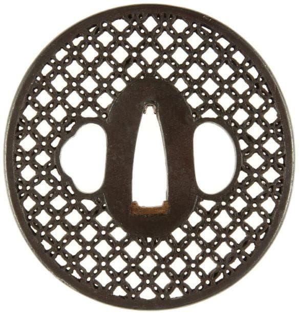 JAPON
Nagamaru gata en fer à décor ajouré en yo sukashi d'un motif géométrique.H. 7,4 cm