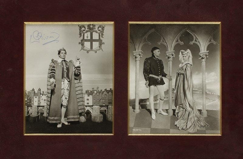 Laurence OLIVIER (1907-1989). Photographie signée dans Henry V (1944); encadrée avec une autre photographie du film, 24 x 19 cm, tirages argentiques d?époque. Premier film de la trilogie shakespearienne réalisé par Laurence Olivier, jouant le rôle-titre, en 1944.{CR} On joint un ensemble de 57 photos d?époque en tirages argentiques (la plupart 18 x 24 cm) et 5 images en couleurs sur papier