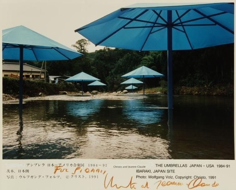 Christo Javacheff, dit CHRISTO (né en 1935)
The Umbrellas JAPAN-USA 1984-91, Ibakari, JAPAN site. Tirage argentique d'époque légendé et fragment de tissu. Signé par Christo et Jeanne-Claude et dédicacé. 20 x 25,5 cm (photo) et 15 x 24 cm (tissu)