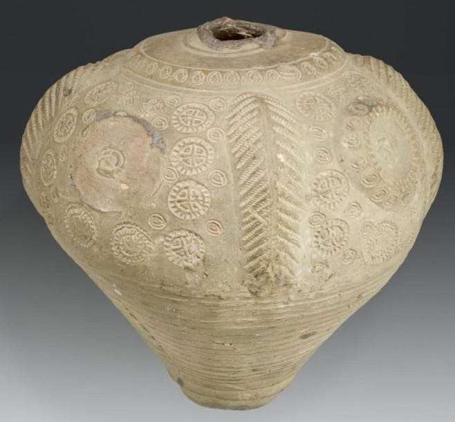 Grand vase sphéro-conique d'alchimiste, Iran, XIIe-XIIIe siècle Vase en céramique argileuse grésée, à décor appliqué et estampé de médaillons cruciformes et de stries tracées à la roulette. H.: 25,5 cm - D.: 26 cm (Accidenté, trou et col manquant) Exposition: A l'ombre d'Avicenne. La médecine au temps des califes, I.M.A., Paris, 18 novembre 1996-2 mars 1997, cat. 55, p. 142.Ce vase appartient au grand groupe de céramiques dites sphéro-coniques en référence à leur forme. Elles présentent généralement une pâte peu filtrée, le plus souvent grésée, et un décor appliqué ou estampé, comme dans le grand vase présenté ici. Leurs dimensions sont très variables, et elles ont été trouvées dans de très nombreux contextes archéologiques, renforçant le mystère concernant leur fonction. Car en effet, on a parfois proposé de les interpréter comme des flacons de parfums, ou de boissons fermentées, particulièrement de vin et de bière, ou encore de mercure. On a également envisagé de les identifier comme des grenades incendiaires et enfin, comme des éolipiles servant à augmenter la chaleur d'un foyer. La variété des formes et des dimensions laisse en réalité à penser à des usages multiples, fonction des contextes et des périodes. Dans le cas présent, les dimensions tout à fait remarquables de ce vase laissent à penser qu'il aurait été utilisé comme cucurbite pour distiller des préparations, probablement en contexte alchimique. Voir A l'ombre d'Avicenne. La médecine au temps des califes, I.M.A., Paris, 18 novembre 1996-2 mars 1997, p. 138-142
