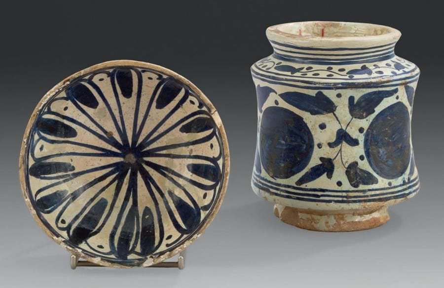 Coupe, et albarelle, Catalogne, XVIIe-XVIIIe siècle Faïences à décor peint en bleu sur fond blanc. Le premier à décor radiant de bandes bleues, et le second, de disques festonnés encadrés de fougères «helechos». D.: 14,5 cm - H.: 15 cm (Manques et restaurations sur les deux)