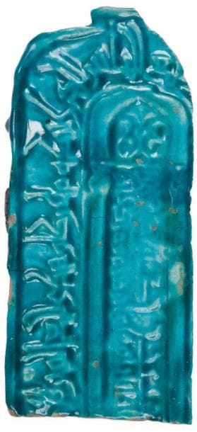 Partie de mihrab portatif, Iran, XIIIe siècle Céramique siliceuse moulée sous glaçure turquoise. Mihrab en arc en plein cintre à décrochement sommital orné d'une niche sur colonnettes à voûte en cul-de-four meublée d'un fleuron, et fond tapissé d'une inscription coufique. L'arc est bordé d'une seconde inscription coufique donnant le verset 96 de la sourate III, «La famille de ?Imrân». H.: 28,5 cm (Tronqué sur la moitié droite, une fracture restaurée)