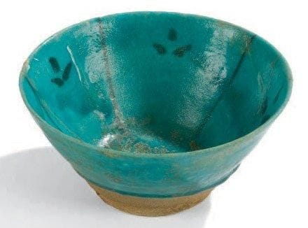 Coupe au décor folié, Iran, XIIIe siècle Coupe tronconique en céramique siliceuse, à décor peint en noir sur engobe et sous glaçure turquoise de compartiments ornés de feuilles. D.: 17,5 cm (Deux fractures recollées et petites irisations)