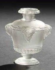 RENE LALIQUE (1860-1945)
Bouquet de Faunes, grand modèle dit aussi Vasque Louis XVI, pour GUERLAIN, au registre des modèles le 7 août 1925 Flacon à parfum. Corps en verre blanc soufflé moulé. Bouchon en verre blanc moulé pressé. Marqué GUERLAIN Paris en relief sur l'urne et Made in France sur la tranche du piédouche. Hauteur: 13,3 cm Bibliographie: «R. Lalique, catalogue raisonné de l'oeuvre de verre» par Félix Marcilhac. Éditions de l'Amateur, Paris, 2004. Modèle identique reproduit page 940 et inscrit sous la référence Guerlain-1. Provenance: Collection Madame H. Paris