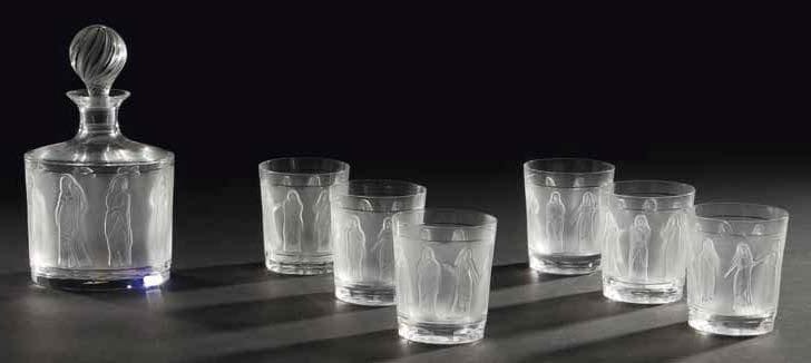 Marc LALIQUE (1900-1977)
Femmes Antiques, modèle créé vers 1962 Service à whisky en cristal composé de six verres et une carafe. Épreuves en cristal soufflé moulé et en partie satiné. Bouchon de la carafe en cristal moulé pressé et, en partie, satiné. Pièces neuves vendues dans leur emballage LALIQUE d'origine. Circa 1974. Chaque pièce signée LALIQUE France en lettres cursives sous la base. Hauteur carafe: 25 cm A noter: Une photocopie de la facture d'origine datée de 1974 sera remise à l'acquéreur
