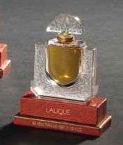 LALIQUE Parfums - Fondé par Marie-Claude LALIQUE (1935-2003)
Chèvrefeuille, modèle créé en 1992 Flacon de parfum d'après un dessin de Marie-Claude Lalique. Épreuve en cristal soufflé moulé et moulé pressé satiné. Scellé et parfum d'origine. Présenté dans son coffret d'origine. Édition limitée et numérotée C 082. Signé LALIQUE © France en lettres cursives vers la base. Hauteur: 8,5 cm Provenance: Collection Madame J.B. Paris