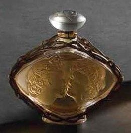 LALIQUE Parfums - Fondé par Marie-Claude LALIQUE (1935-2003)
Le Baiser, Collection 2 000 Flacon de parfum. Corps en cristal soufflé moulé et en partie satiné, enchâssé dans une monture en métal doré à l'or fin. Bouchon en cristal moulé pressé. Scellé et parfum d'origine. Vendu dans son coffret d'origine. Édition limitée et numérotée D 79. Signé LALIQUE © France en lettres cursives sur la base, coffret titré et marqué. Hauteur flacon: 11 cm Emboîtage: 16 x 15 x 8 cm Provenance: Collection de la Côte d'Azur
