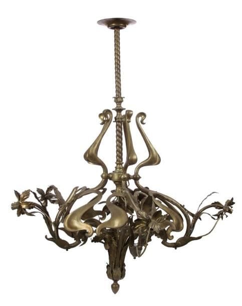 TRAVAIL ART NOUVEAU
Spectaculaire lustre naturaliste à onze lumières réalisé en bronze et laiton.. Décor de larges volutes mouvementées, façon coup de fouet, exécutées en bronze et de fleurs en cuivre repoussé, ciselé et ouvragé.. Hauteur: 145 cm. Diamètre: 125 cm