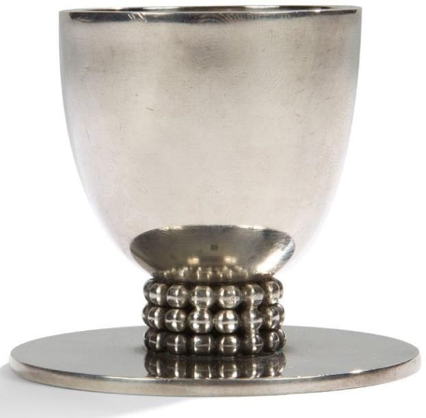 Jean DESPRES (1889-1980)
Coquetier en métal argenté. La base ornée d?une double rangée de sphères repose une terrasse circulaire. Vendu dans son coffret de chez DESPRÉS Avallon. Signée J. DESPRÉS à la pointe au revers. Hauteur: 5,2 cm. Provenance:. Ancienne collection de Monsieur et Madame X., près d?Avallon (Yonne), oeuvre acquise directement auprès de l?artiste