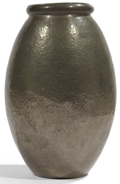 Jean DESPRES (1889-1980)
Haut vase ovoïde à col renflé légèrement oblong et traité lisse. Épreuve en dinanderie d?étain à la surface entièrement martelée. Léger enfoncement sur le col et infimes déformations éparses sur le corps du vase. Signé J. DESPRÉS sous la base. Hauteur: 31 cm