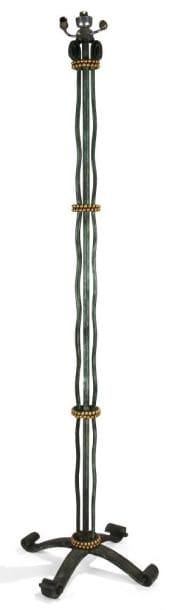 EDGAR BRANDT (1880-1960)
Pied de lampadaire en fer laqué verde antico. Le fût est constitué de lames verticales ondulantes terminées par une crosse aplatie dans leur partie haute et réunies par quatre bagues en double rangée de sphères patinées or. Base quadripode, au décor sur les arêtes d?olives et de boules en alternance, achevée en enroulement aux réceptions. Épreuve d?édition ancienne, circa 1930. Signé du cachet Edgar BRANDT sur un des pieds. Hauteur (sans système électrique): 170 cm