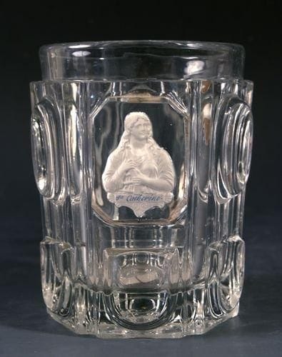 Grenelle
Gobelet en cristal moulé de pastilles ovales et festons, orné du buste de sainte Catherine. Haut. 10,3 cm.