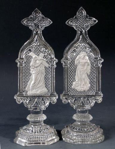 SAINT-LOUIS
Paire d?ornements sur pied et croix sommitale en cristal moulé pressé à motif de grains de sel, l?un orné d?un Christ portant sa croix, l?autre d?un Christ portant un agneau sur ses épaules. Haut. 19,5 cm.