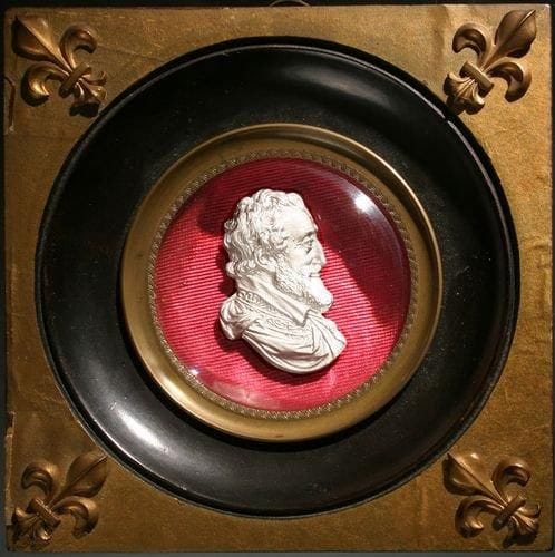 Plaque ronde en cristal orné du profil droit du roi Henri IV. Cadre carré en bois noir et doré à quatre fleurs de lys et jonc en cuivre. Haut. 10,7 cm.