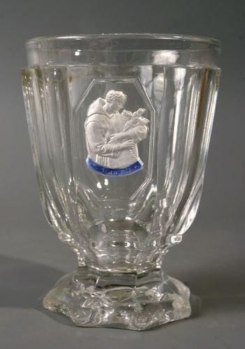 BACCARAT
Gobelet à piédouche en cristal moulé à côte plate orné du buste de saint François. Haut. 12 cm.