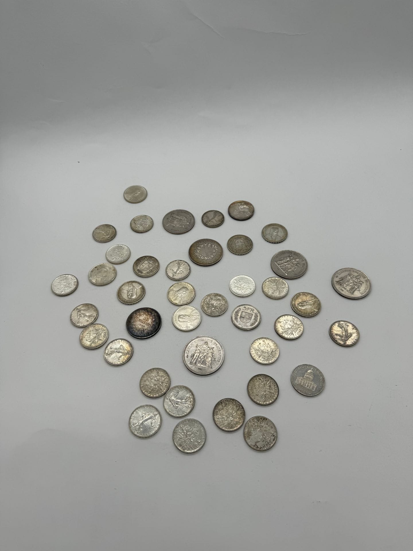 Lot of 41 silver and silver-plated coins and medals including : 
5 silver 50-franc coins, Hercules type 
1 aregnt 10-franc silver coin, Hercules design 
23 5-franc silver coins, Semeuse design.
1 silver 5-mark coin
9 Swiss 5-franc silver coins 
1 silver 100-franc coin, 1983 tree design
1 Munich Olympic Games commemorative medal
Net weight: 605 g
Silver-plated medals and coins.