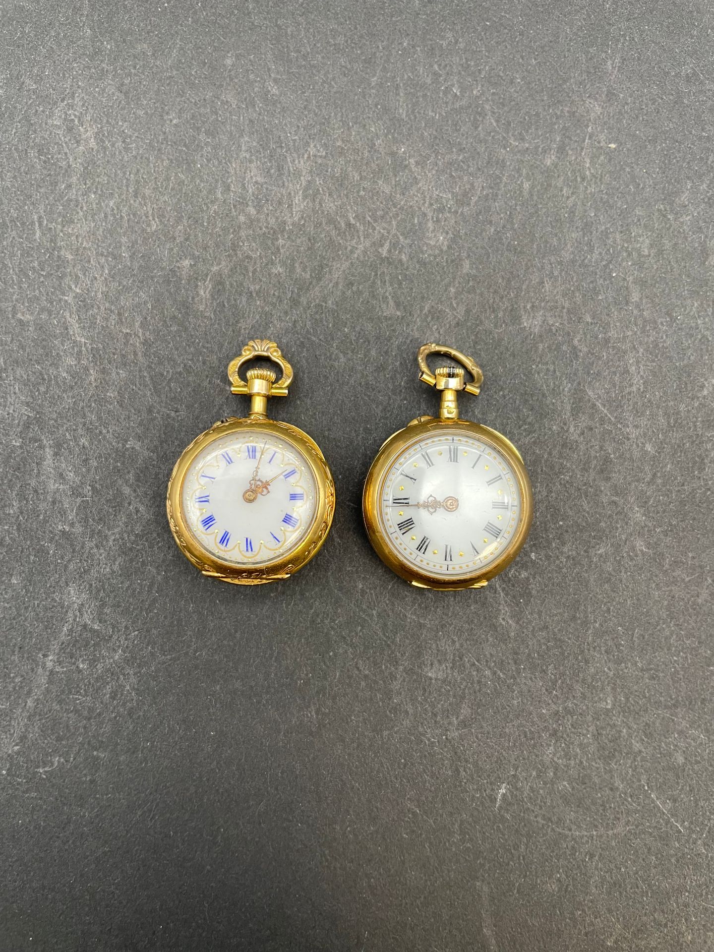 Deux montres de col en or jaune 750/°°° poinçons tête de cheval :
- l'une chiffrée au verso Poids brut 15.80 g
- l'autre à décor floral ajouré Poids brut : 15.60 g

Poids total brut : 31.4 g.