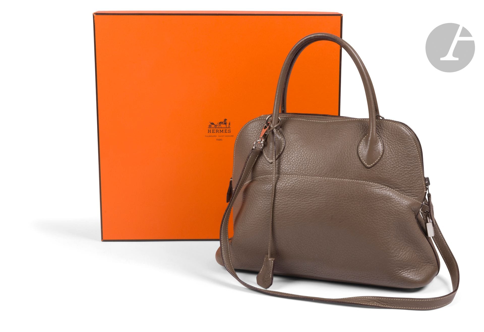 HERMES Paris Made in France
Bolide bag in grained etoupe leather, palladium metal trim, removable shoulder strap signed, two keys under bell and padlock. Year 2006. In box, with cover. 32 x 24 x 11.5 cm
(pen marks inside, some minor wear, notably at the corners, minor marks on the leather).