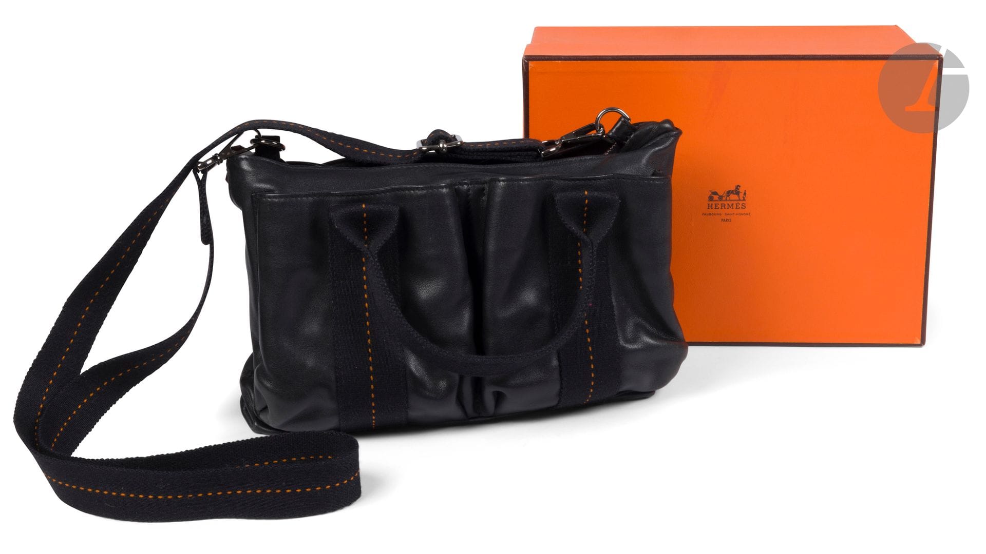 HERMES Paris Made in France
Caravane small shoulder bag in black leather with black straps with orange stitching, removable matching canvas shoulder strap, in box, with bag. 29 x 18 x 9 cm (a few small marks on the leather).